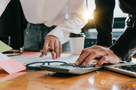 Business woman analysis on data paper with business man using calculator at the office, Business finance conceptの写真素材