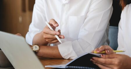 Business team brainstorming and discussing financial report graph with laptop computer.の写真素材