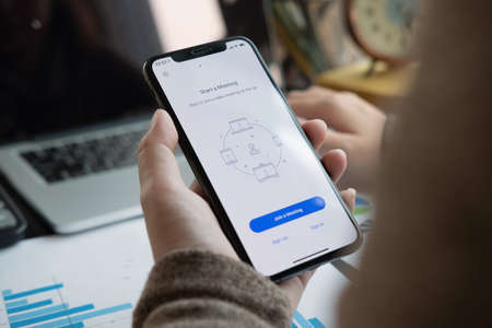 CHIANG MAI, THAILAND - APR 11, 2020 : A working from home employee is downloading the Zoom application social platform,のeditorial素材