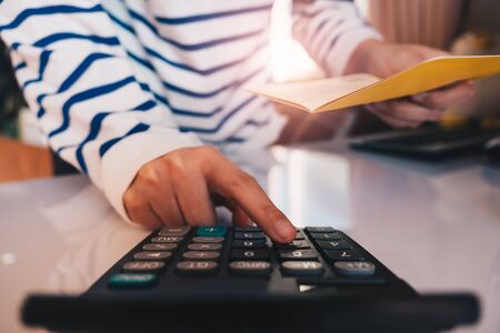 Business hands holding saving account passbook with calculator,の写真素材