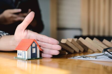 Protect the house from falling over the wooden blocks, Insurance and risk concept.の写真素材
