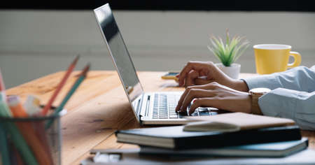 Close up Woman working at home office hand on laptop keyboardの写真素材