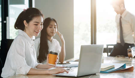 Young asian business people working with documents together at modern officeの写真素材
