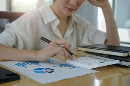 Closeup hands of businesswoman or accountant working on desk office with using a calculator to calculate the numbers, finance accounting conceptの写真素材
