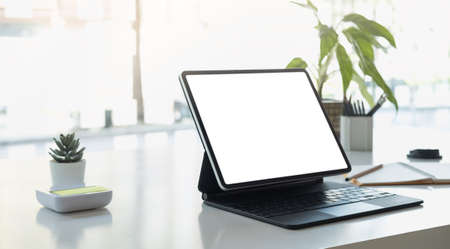 Cropped shot of workplace with tablet blank screen and office supplies in simple workspace.の写真素材
