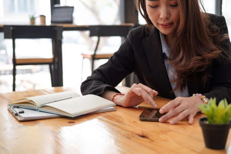 business, technology concept - Portrait of woman hands texting message on smartphone at office.の写真素材
