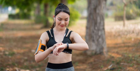Young woman workout at outdoor using smart watch healthy lifestyle.の写真素材