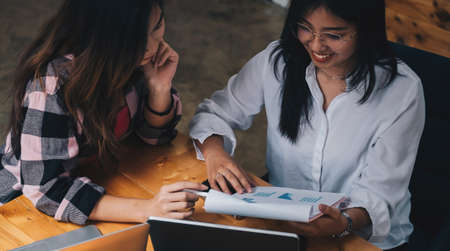 Two businesswomen discussing for financial chart report in office.の写真素材