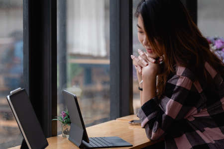 Shot of young asian creative designer working at cafe with digital tabletの写真素材