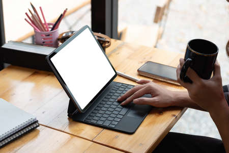 Close up hand of woman using blank screen digital tablet while working on his project.の写真素材