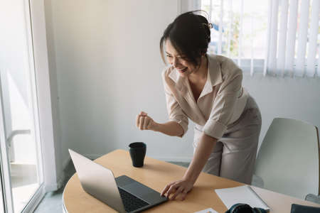 Excited Asian Businesswoman Celebrating Success At Workplace.の写真素材