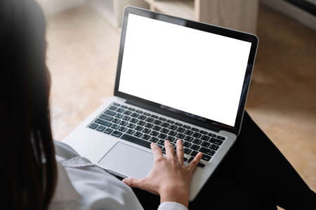 young woman working with laptop computer at home, empty screen displayの写真素材