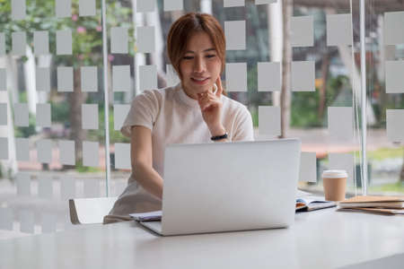 Portrait of asian female working with laptop computer for online business or education concept.の写真素材