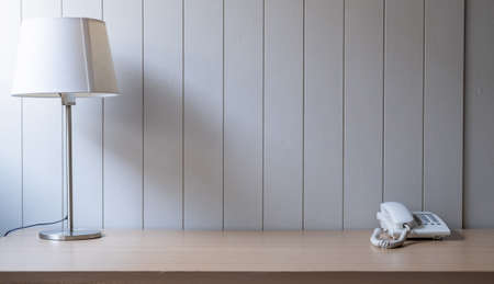 Workplace with space - Lamp on old wood table with space of rough cement wall in white color tone.の写真素材