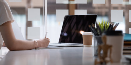 Close up hand of female graphic designer sketching on her project with digital teblet at modern creative workplaceの写真素材