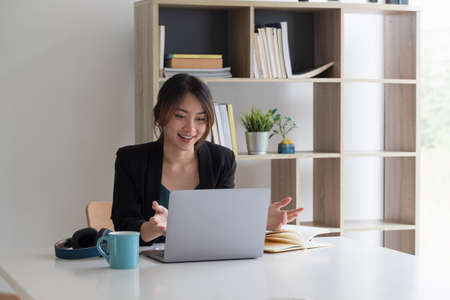 Beautiful business female resourceful person looking notebook table watching online training minded sit chair formalwear blazer modern office.の写真素材