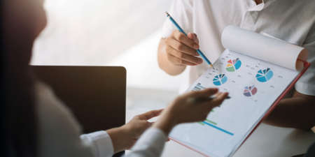 Close up business people discussing the charts and graphs showing the results of their successful teamworkの写真素材