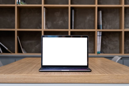 Laptop with blank screen on table in library roomの写真素材