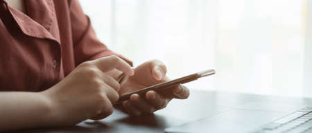 Close up hand of woman using smart phone.の写真素材