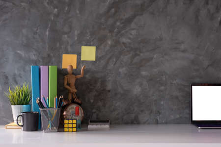 Cropped shot of workspace with mock-up laptop with white blank screen, Home interior or office background.の写真素材
