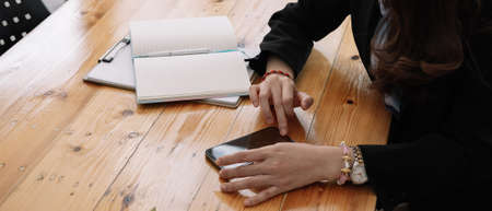 business, technology concept - Portrait of woman hands texting message on smartphone at office.の写真素材