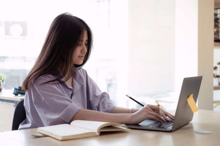 Online education. Asian girl online lesson using a computer video call to a virtual teacher at homeの写真素材