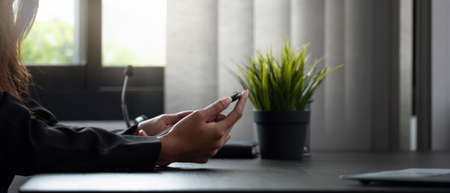 Close up woman use of smart phone at her officeの写真素材