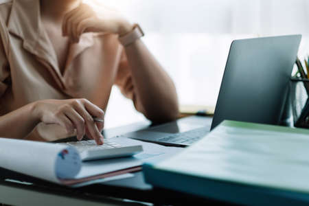 businessman working on desk office with using a calculator to calculate the numbers, finance accounting concept.の写真素材