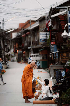 CHIANG KHAN , LOEI, Thailand - 21 OCT, 2020 : Thai monks go with a bowl to receive food or Sticky rice from tourist in early morning at ChiangKhan Walking street, Loei Province, Thailandのeditorial素材