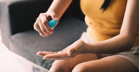 Close up hand of lady that applying alcohol spray or anti-bacteria spray to prevent the spread of germs, bacteria and virus. Personal hygiene conceptの写真素材