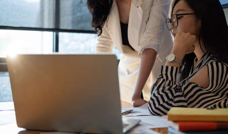 Business people meeting in office and discussing over a documents, two woman with a financial report...