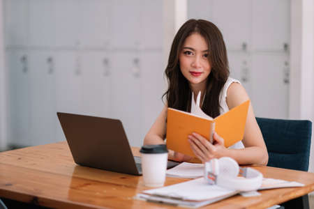 Portrait of businesswoman on workplace. Happy young Asian girl working at a coffee shop with a...