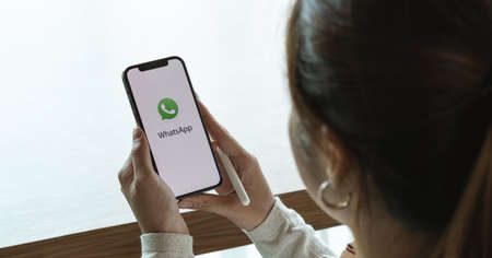 CHIANGMAI, THAILAND - JULY 3, 2021 : Female hand holding WhatsApp mobile application on apple iPhone...