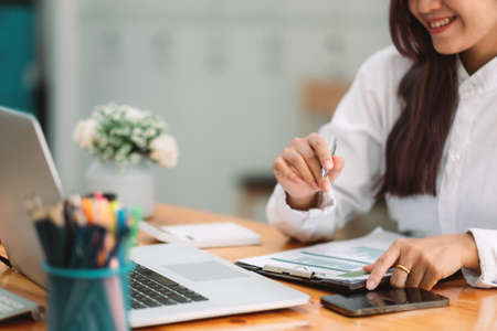Businesswoman using calculator for analysis maketing plan, Accountant calculate financial report,...