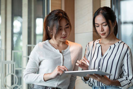 Creative idea teamwork concept. Group of asian woman using digital tablet and pen stylus drawing at officeの写真素材