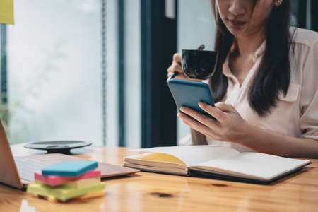 Business attractive young asian woman usgin smartphone at office. business financial conceptの写真素材