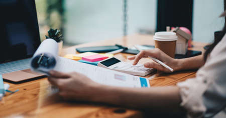 Close up businesswoman or lawyer accountant working financial investment on office, using calculator analysis finance document report real estate and home loan insuranceの写真素材