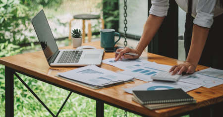 Business woman discussing on stockmarket charts in office, working on laptop computer