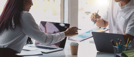 Close up of diverse businesspeople group discussing charts and graphs on meeting, multiethnic team of corporate managers or employees analyzing information materials hardcopy in office together.の写真素材