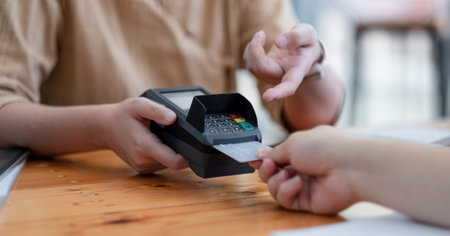 Customer using credit card for purchase to waitress EDC at cashier, Credit card payment conceptの写真素材