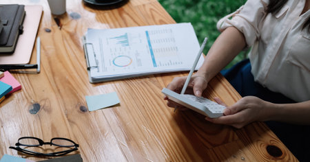 Tax deduction planning concept. Accounting woman calculating business balance prepare tax reduction with calcualtor and monthly reportの写真素材