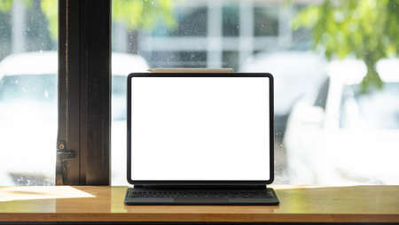 shot of digital tablet with blank white screen on wooden desk