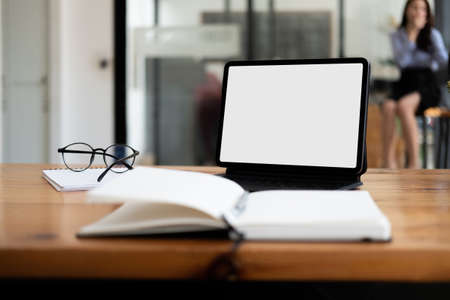 Shot of digital tablet with blank white screen, keyboard, cup of coffee on workspace deskの写真素材