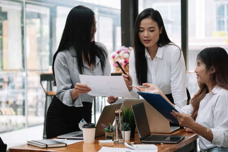 Business asian team discussing working analyzing with financial data and marketing growth report graph in team, presentation and brainstorming to strategy planning making profit of companyの写真素材