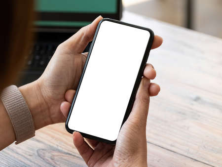 Top view Woman sitting and holding blank screen mock up mobile phone..の写真素材