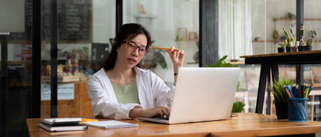 Cropped photo of woman writing making list taking notes in notepad working or learning on laptop...