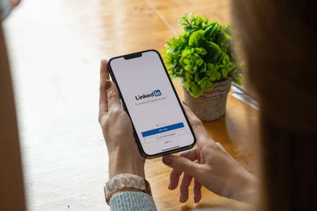 CHIANG MAI, THAILAND, OCT 17, 2021 : A women holds Apple iPhone pro max with LinkedIn application on the screen.LinkedIn is a photo-sharing app for smartphonesのeditorial素材