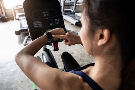 Young woman workout in gym healthy lifestyle, Woman is using smart watch during her workout with...
