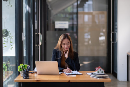 Business asian woman or real estate agent working with laptop computer at her officeの写真素材