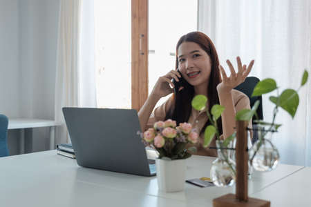 Portrait of young asian woman freelance online working from home with laptop computer during call...
